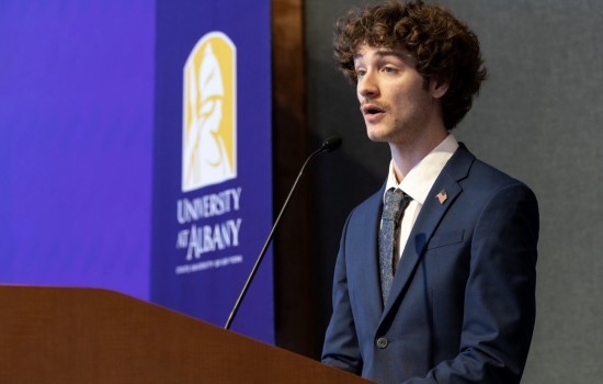 Junior Troy Serao delivers remarks from a UAlbany podium.