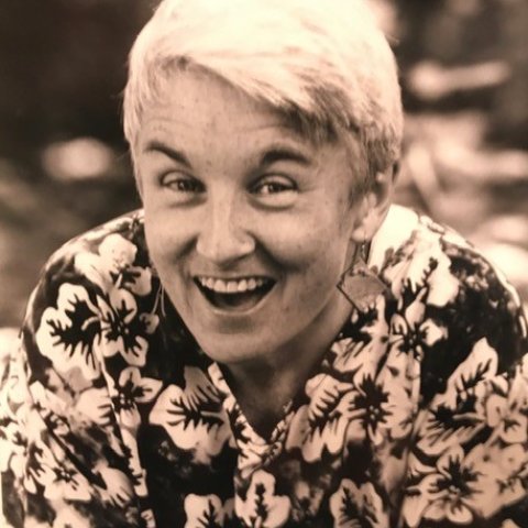 smiling woman with short white hair and flowered shirt