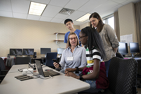 Girls Inc. intern Eureka! working with computer scientists in lab