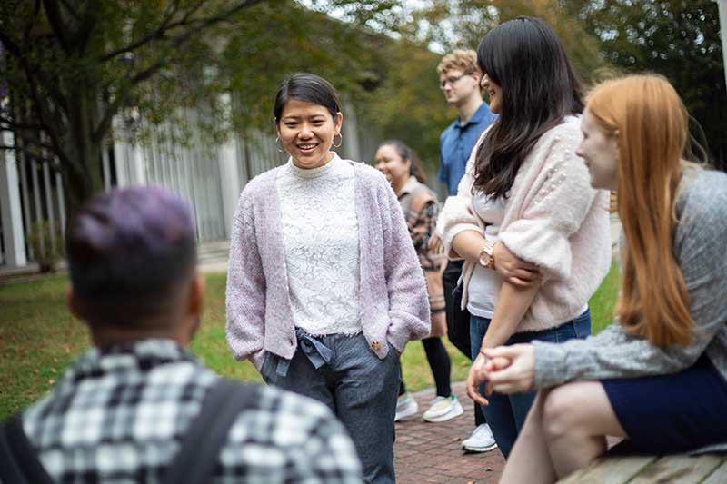 A group of students engaging in conversation while outside on UAlbany campus