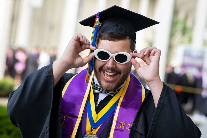 Christian Vitek putting on sunglasses at commencement