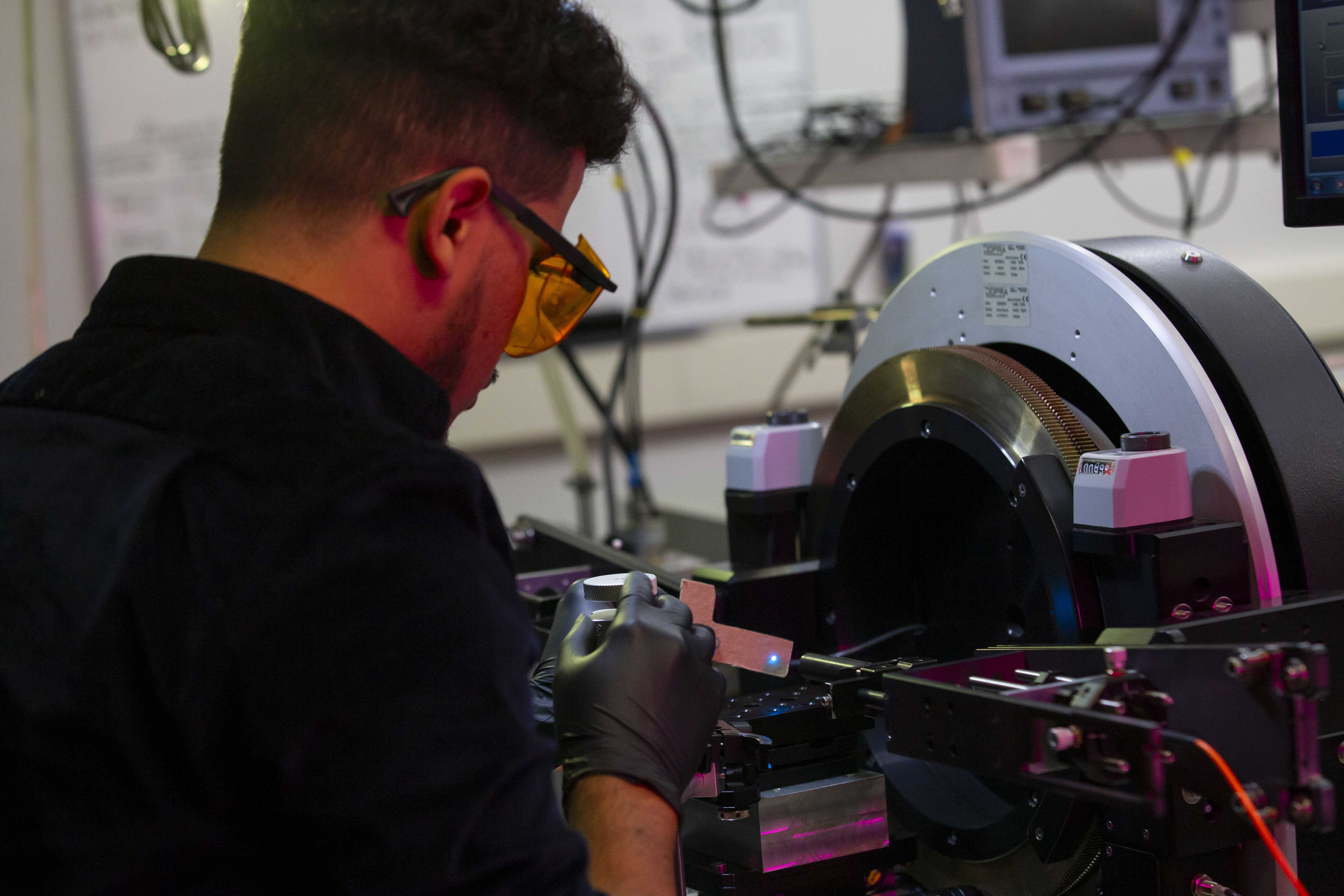 Nanoscale engineering student Kevin Reyes works on a machine at the College of Nanotechnology, Science, and Engineering. (Photo by Brian Busher)