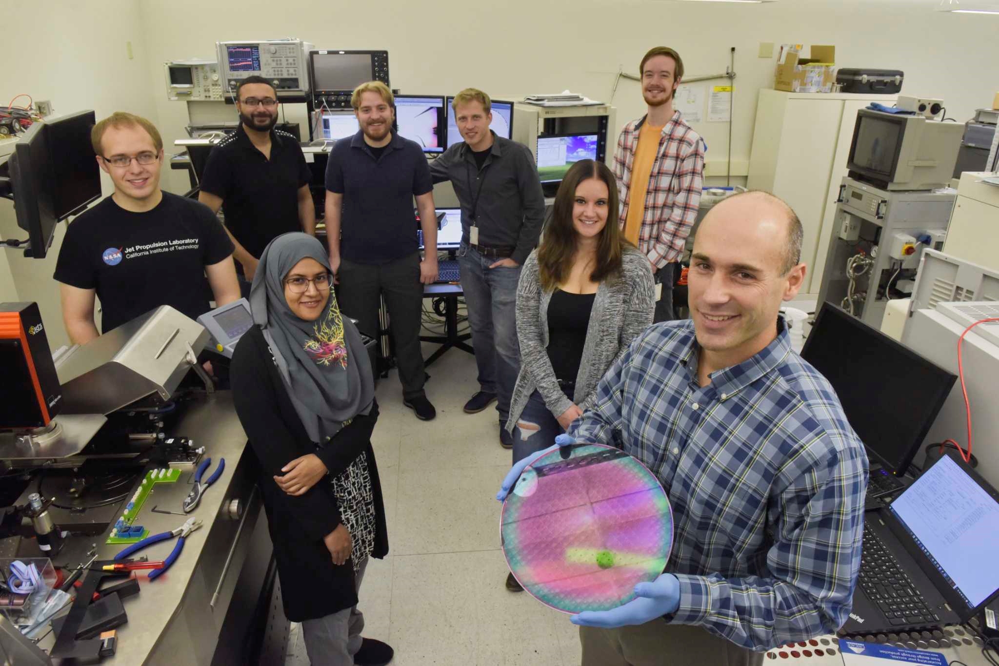 CNSE Professor Nathaniel Cady and student researchers showcase a semiconductor wafer. (Photo by CNSE)