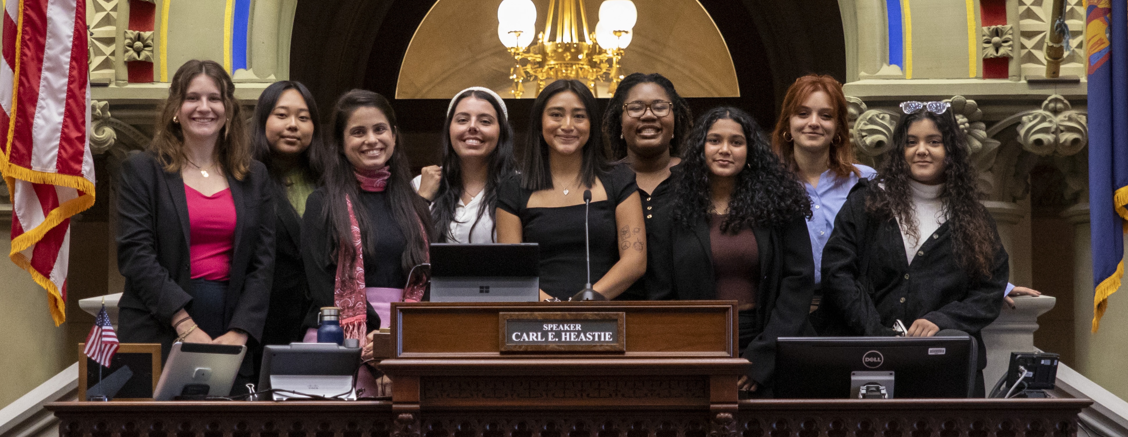 A group of 9 women pose in the New York State Capitol.