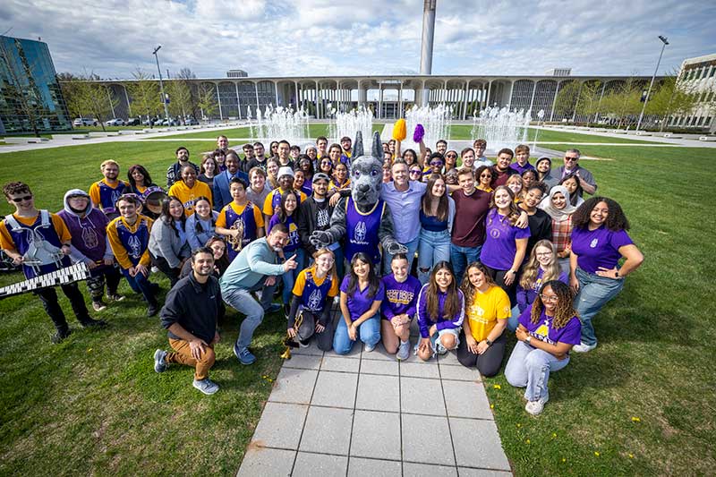 UAlbany students celebrate the filming of The College Tour with host Alex Boylan and UAlbany mascot Damien, the Great Dane