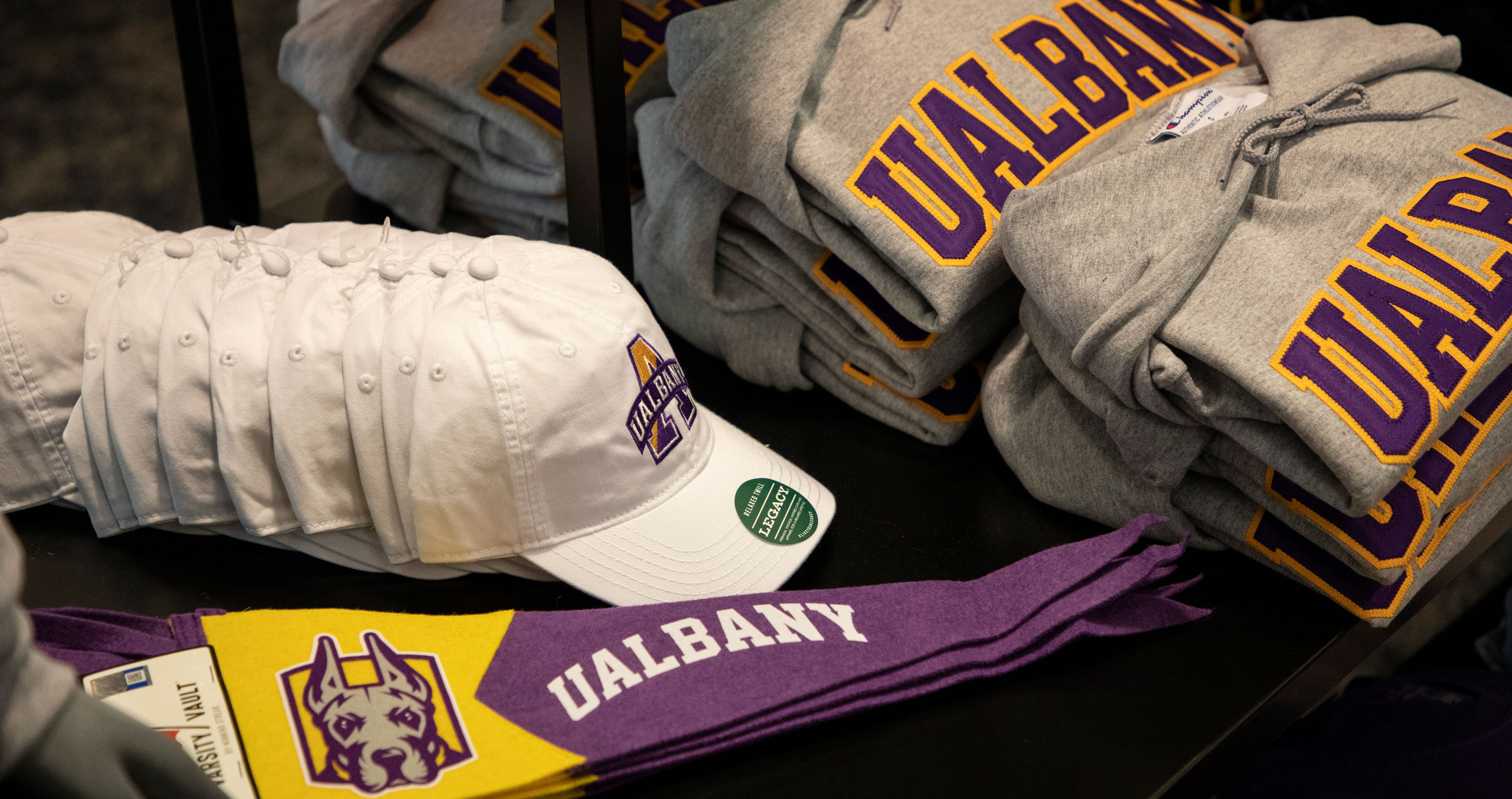 UAlbany branded baseball hats, sweatshirts and pennants for sale at the campus bookstore.