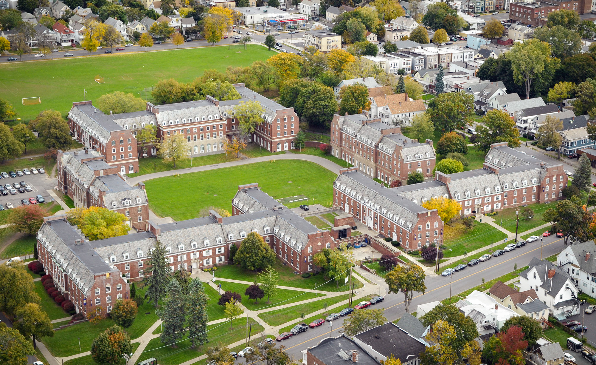 An aerial view of UAlbany's Alumni Quad residence halls, which are brick buildings surrounding a green space.