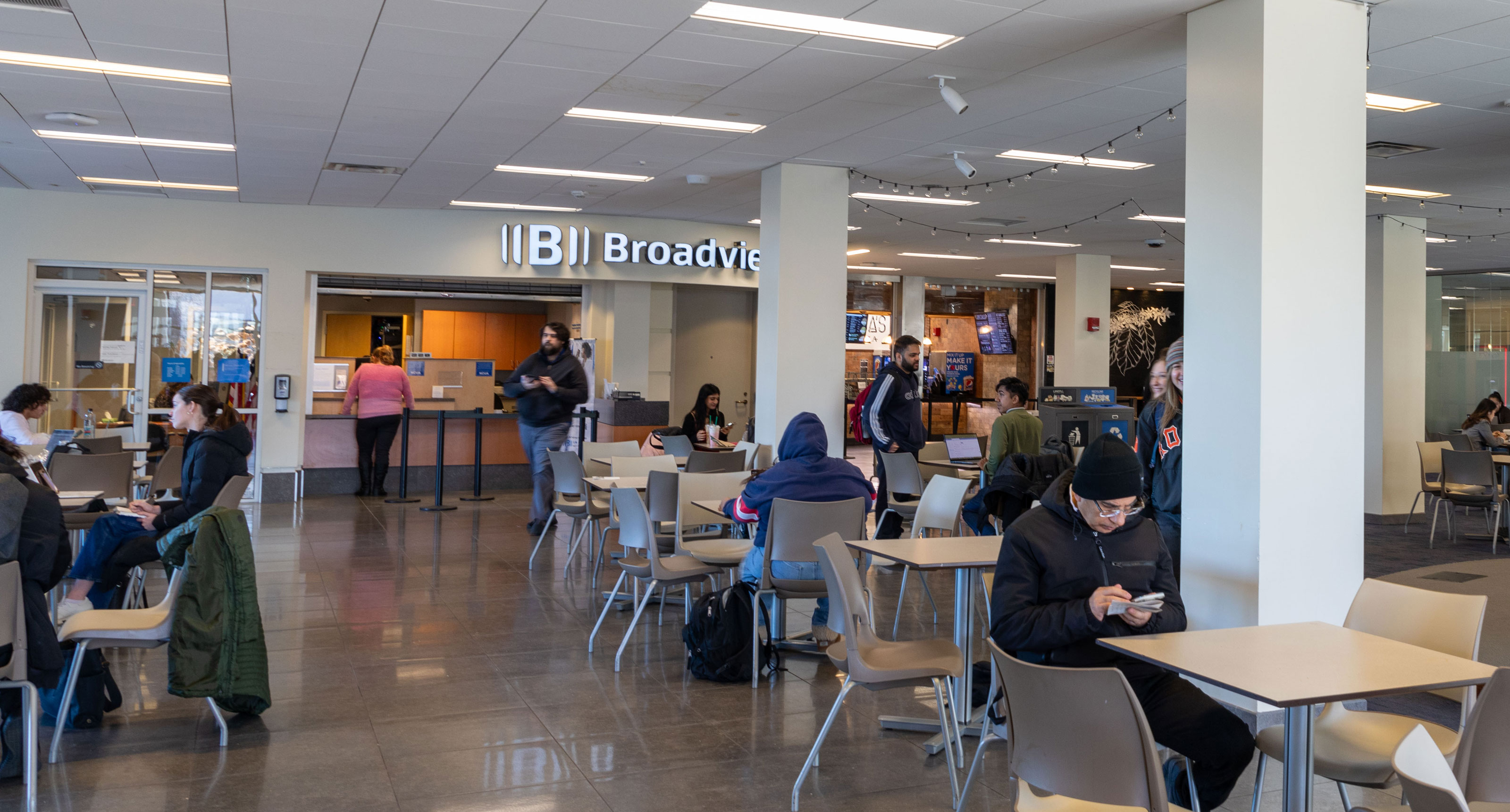 Students walk through UAlbany's Campus Center and past a Broadview Federal Credit Union branch.