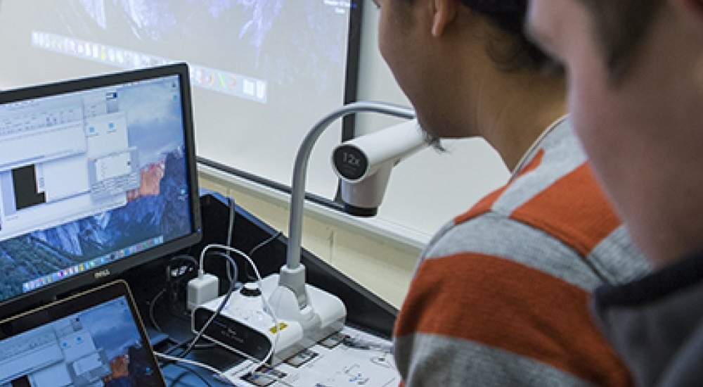 Students study test results on a computer screen.