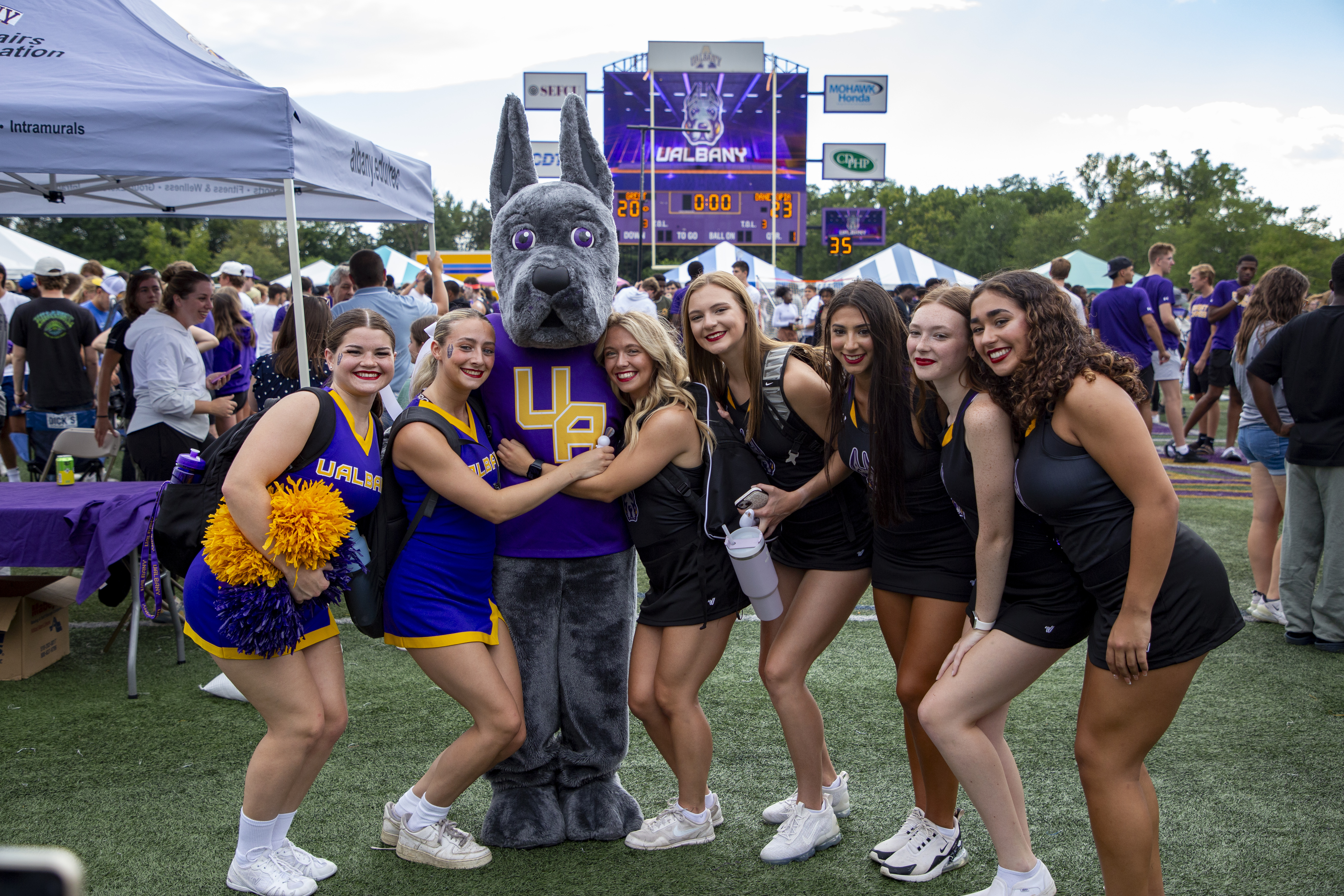 Damien posing with students on Bob Ford Field