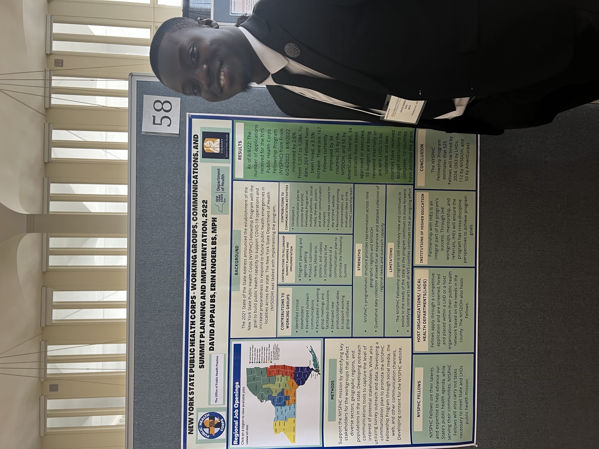 David stands in front of his poster at Poster Day