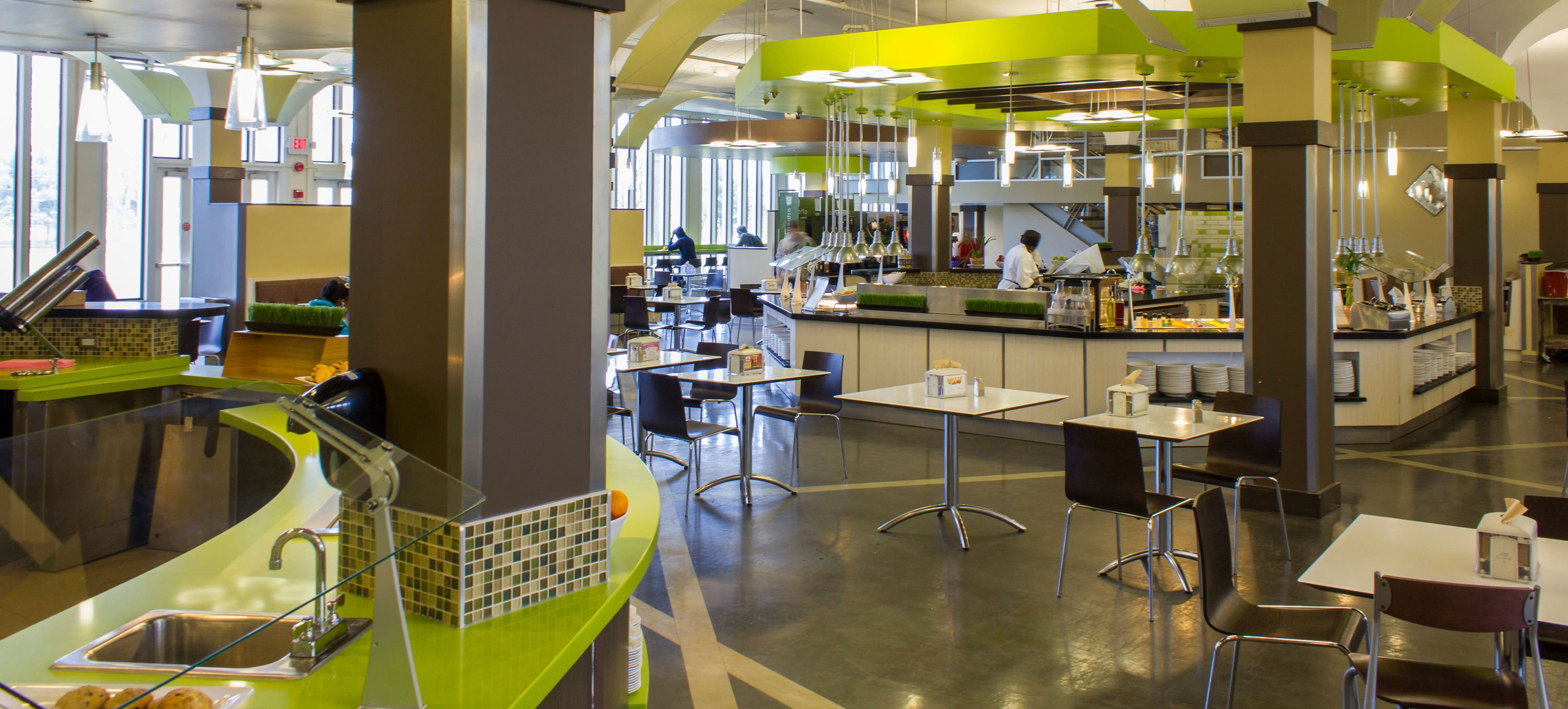 A UAlbany dining hall, with tables, chairs and food stations.