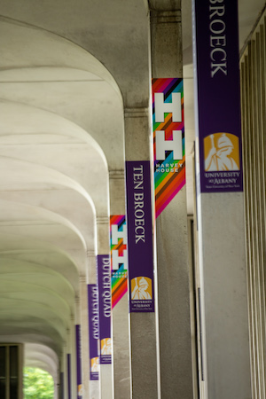 Rainbow signs for Harvey House adorn the columns at UAlbany