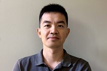 A portrait of a smiling man in a blue polo-style shirt.