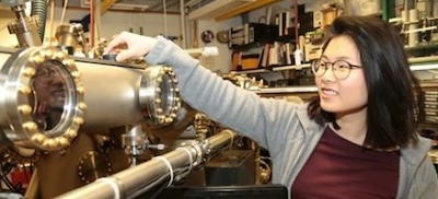 Student researcher Sunny Choi adjusts a sample in an ultra-high vacuum chamber as part of the Summer Undergraduate Research Program.