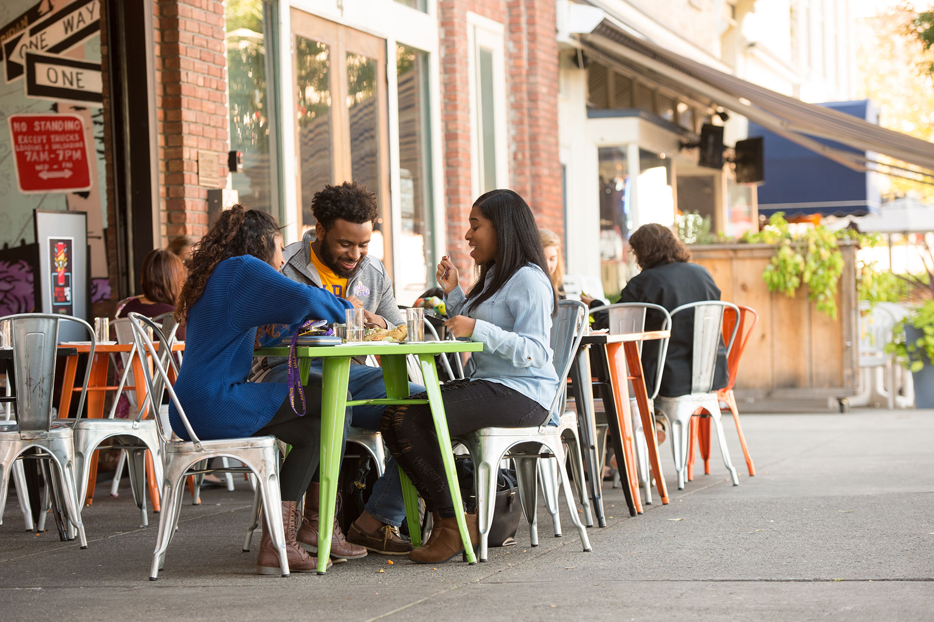 Three students eating together in downtown Albany