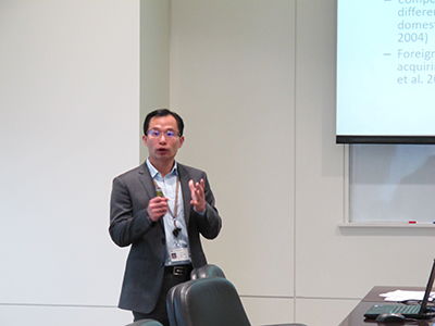 Economics professor Chun-Yu Ho standing in front of classroom presenting.