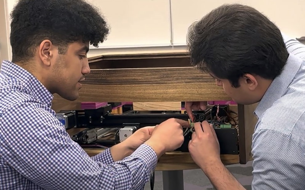 Two students examine equipment