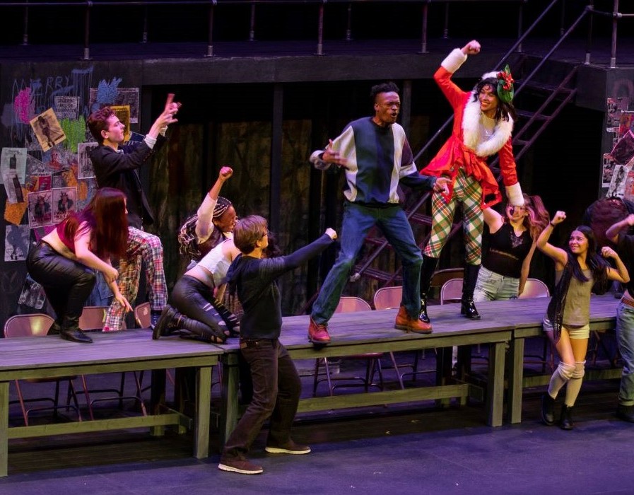 Several actors performing a dance as part of the musical performance of Rent.