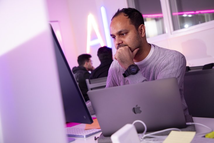 man staring at computer with a lap top in front of him