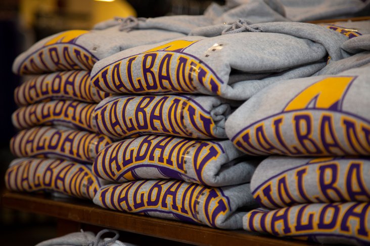 Gray UAlbany sweatshirts neatly folded and stacked inside the campus bookstore.