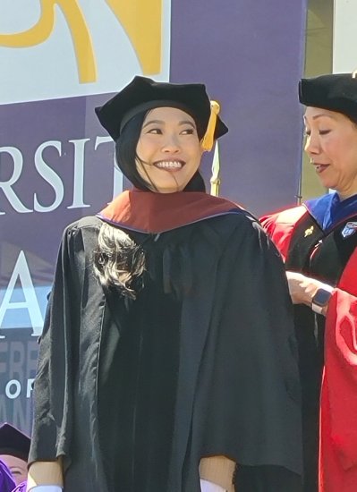 Nora Lum is hooded by UAlbany Provost Carol Kim as she receives her honorary doctorate at UAlbany's commencement ceremony.