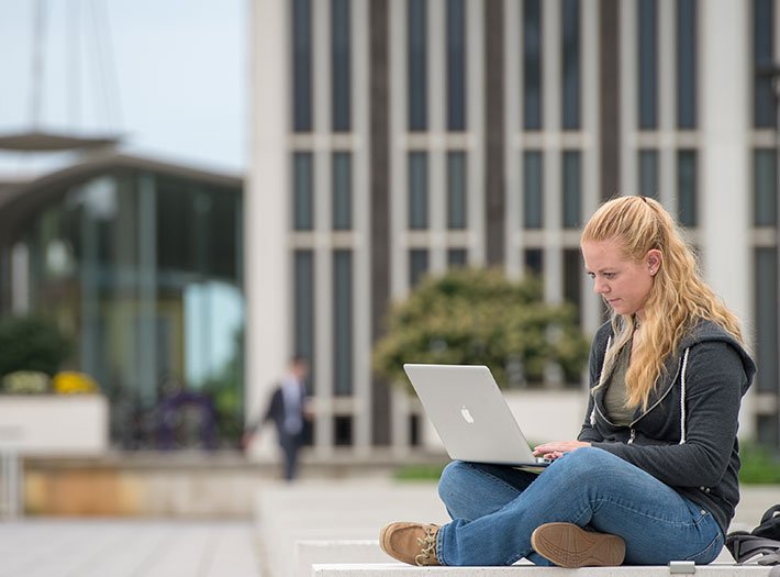 Student studies computer near podium