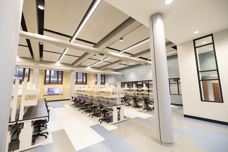 A wide shot of a big laboratory space with several rows of parallel benches and high ceilings