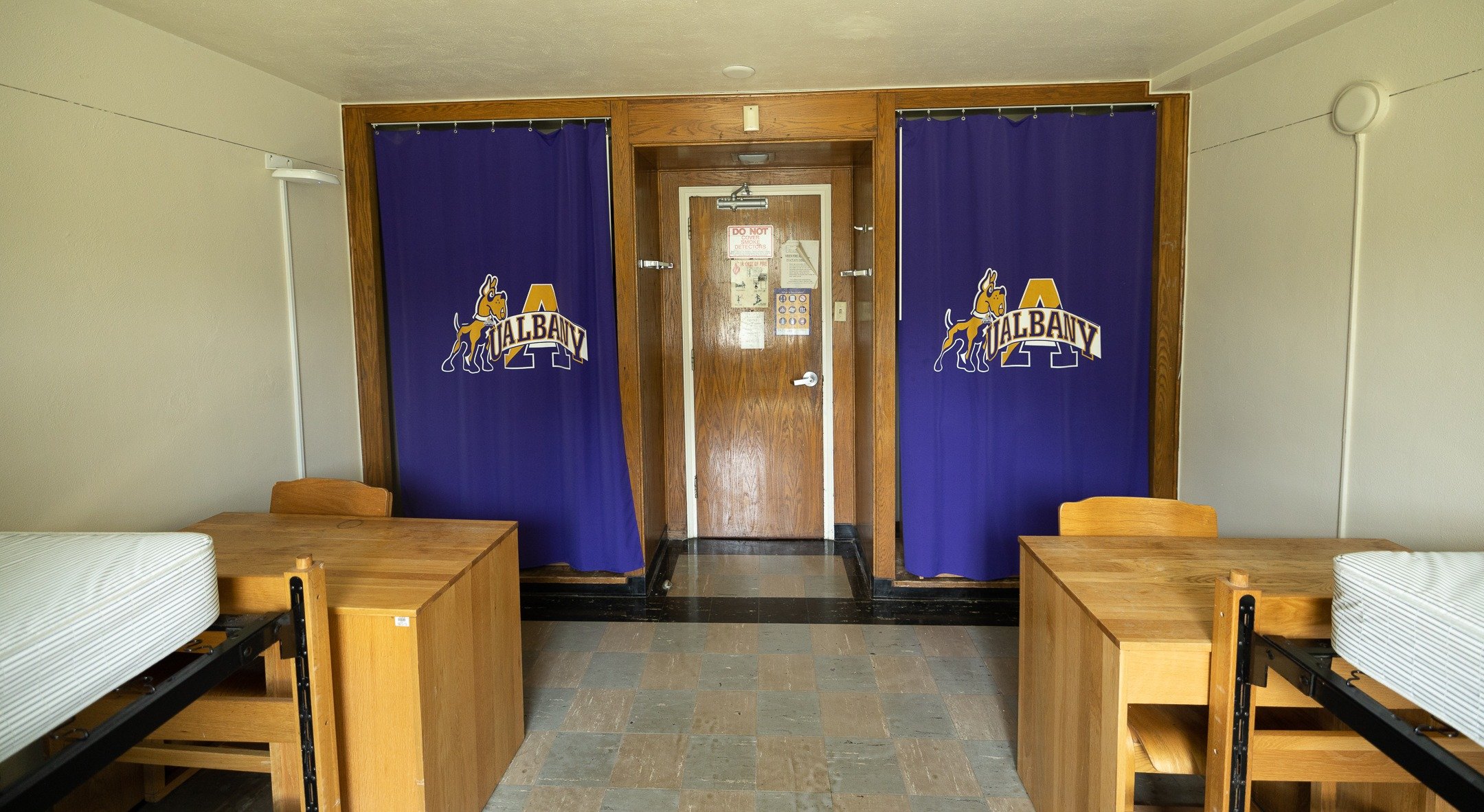 Two closets with purple UAlbany curtains inside a double bedroom on Alumni Quad.