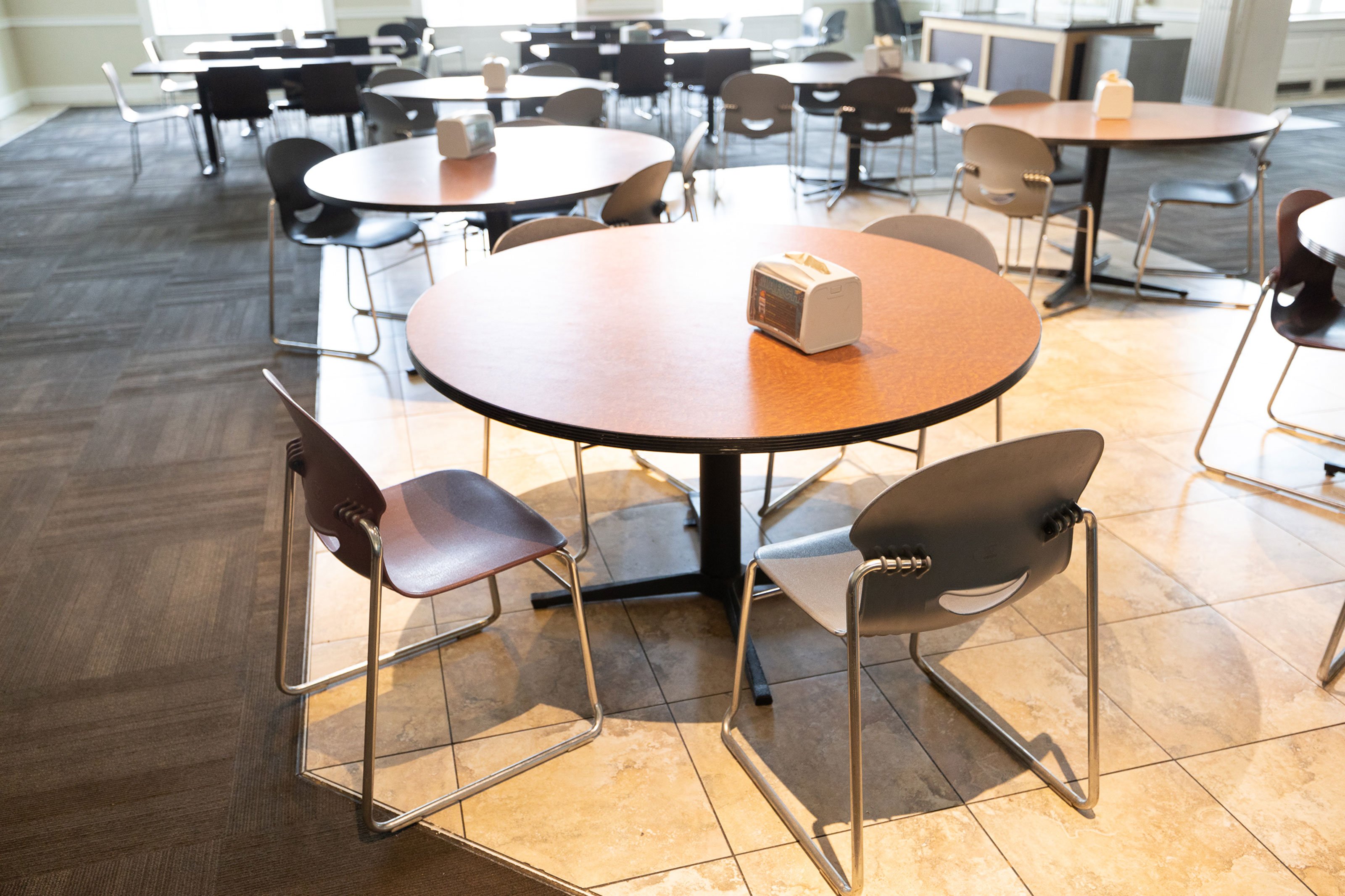 Circular tables surrounded by chairs inside the dining hall on Alumni Quad.