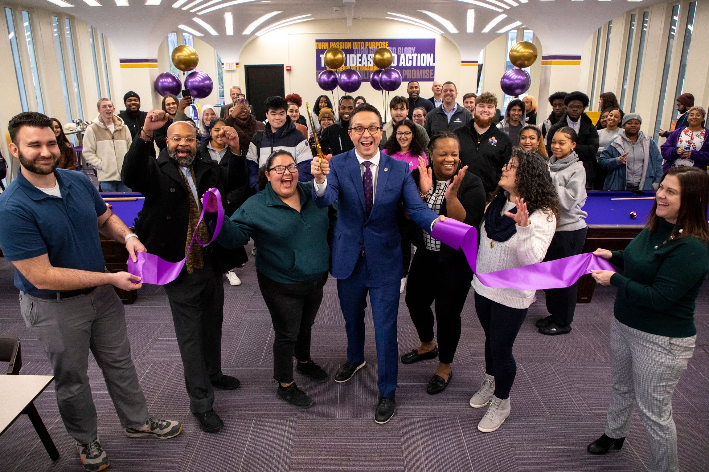 Students and employees celebrate as Vice President Michael Christakis cuts the ribbon for a new game room.