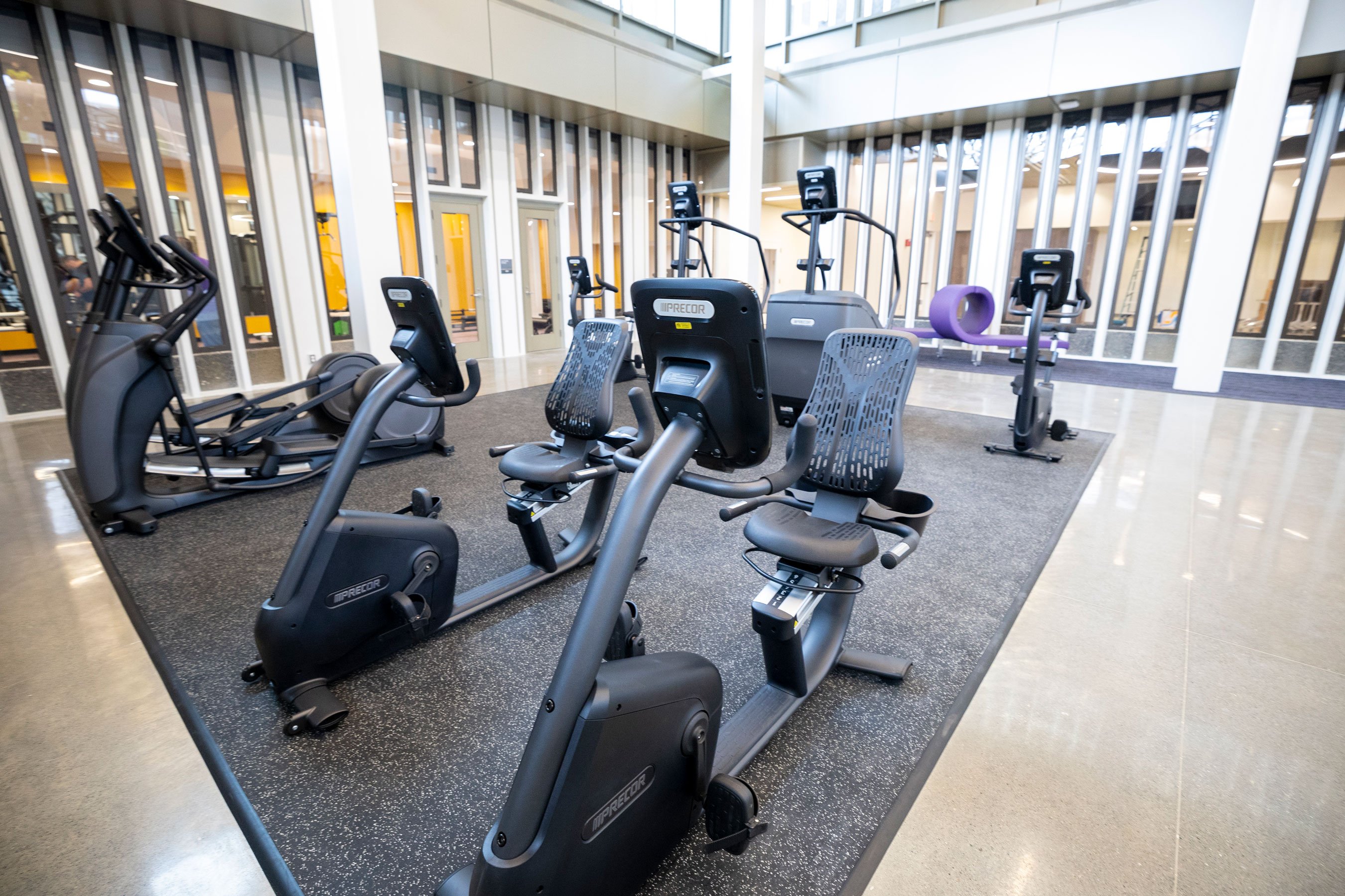 A room with fitness equipment, including ellipticals, bikes and stair climbers.