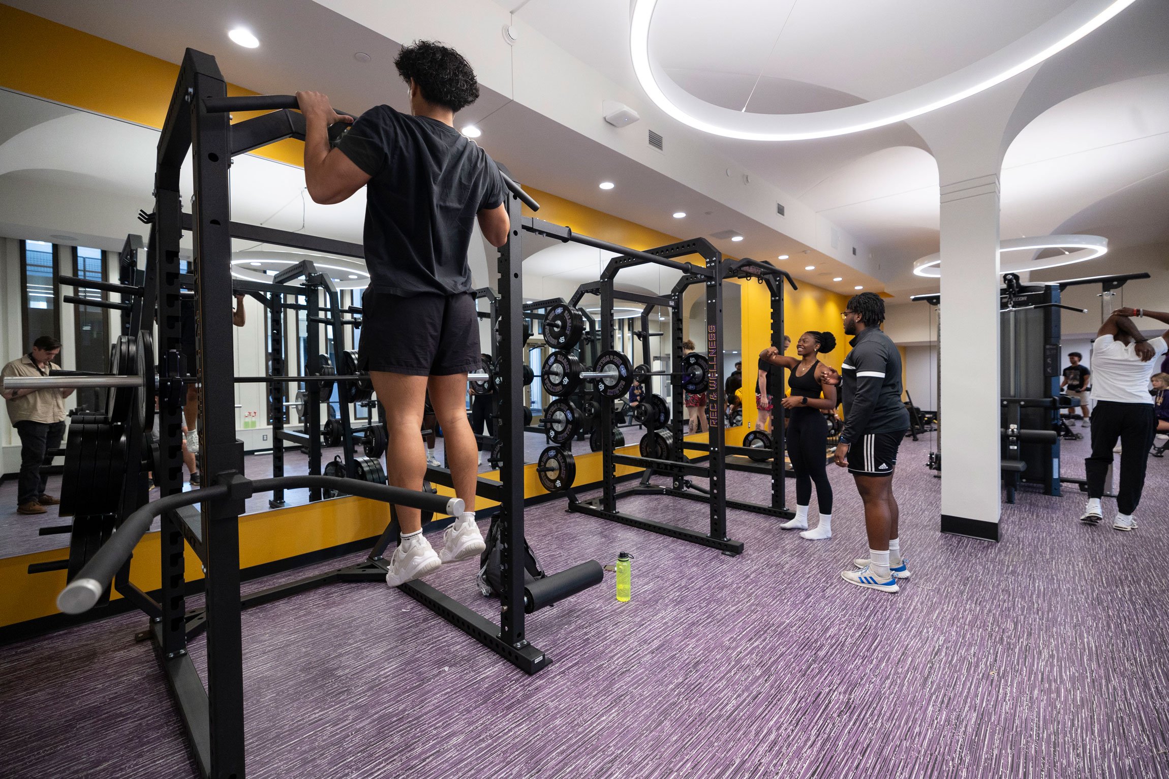 Students work out inside a weight room inside The Well at Colonial.