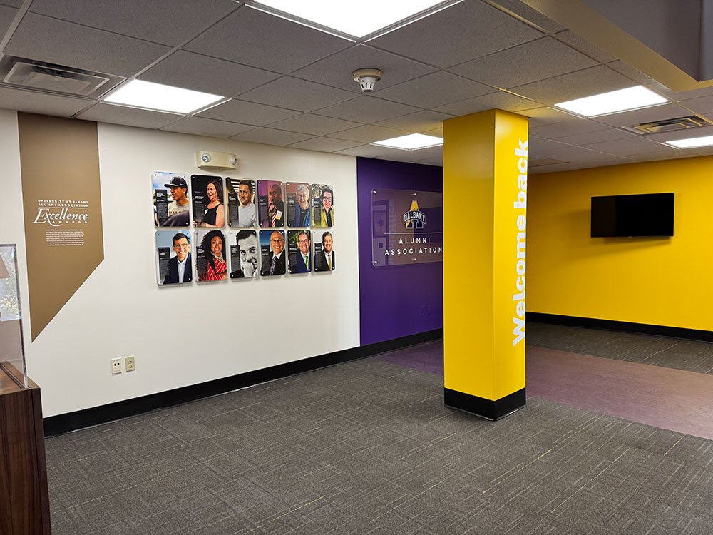 Images of featured alumni on an Alumni Excellence wall display.