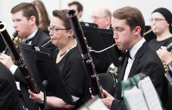 Musicians play instruments with an orchestra.