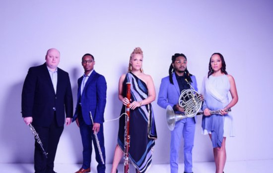 Five musicians pose with their instruments on a purple background