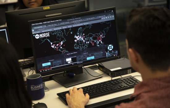 A student views a global threat map on a computer as part of study within the digital forensics lab at UAlbany.