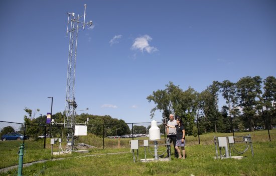 Chris Thorncroft and June Wang point at instrumentation at the NYS Mesonet's ETEC site.