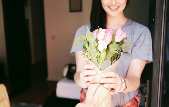 A woman receives a bouquet of tulips