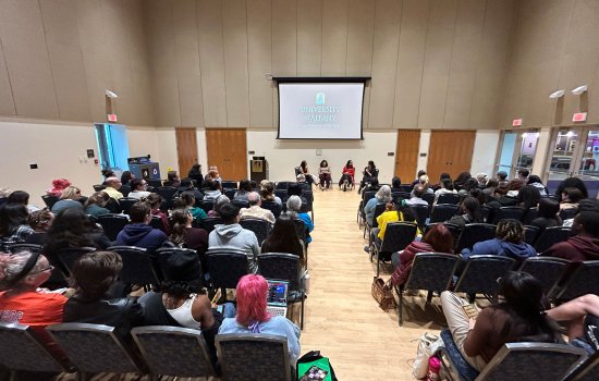 A room full of people listen to four panelists speak during a conversation and Q&amp;A featuring authors Angie Cruz and Lilliam Rivera.