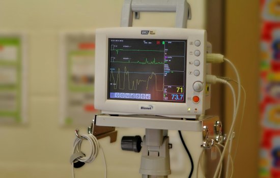 Hospital heart monitor device showing pulse readout on a digital screen