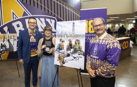 Aliyah Melendez, winner of UAlbany's Holiday Card contest, standing with VP Michael Christakis and President Havidán Rodríguez