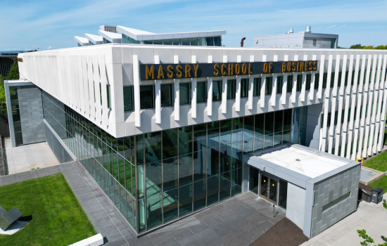 A building with multiple windows and a fully glass bottom, with the words Massry School of Business on it