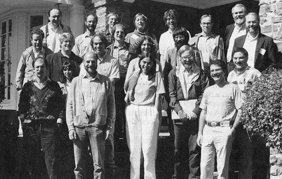 Black and white group photo featuring 21 men and women standing on steps in front of a stone building.