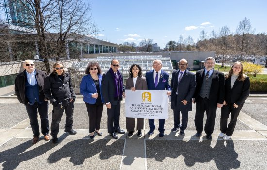 Paul Tonko, UAlbany and community leaders stand in front of the UAlbany greenhouse holding up an ITECA sign.