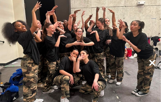 University at Albany Dance Council strike a group dance pose in matching camo and black t-shirt outfits