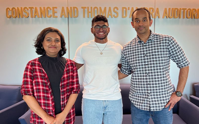 Jiss Louis, Jacob Chacko and Kaalak Reddy stand and smile for a photo outside of UAlbany's D'Ambra Auditorium.