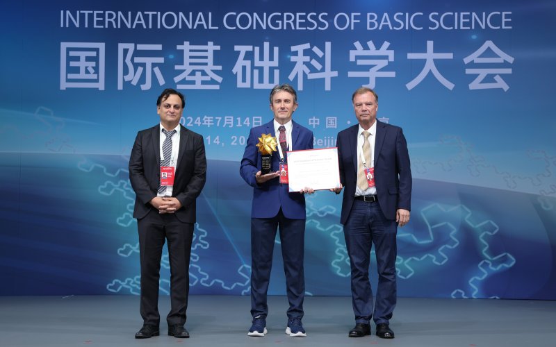 Professor Milas (center) receiving his award, from Babak Haghighat (left) and Nicolai Reshetikhin (right).