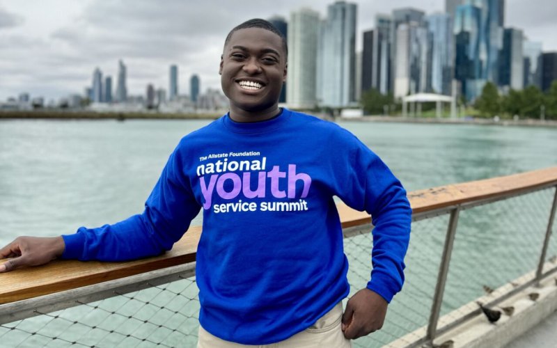  Jaden Gabb stands in front of the Chicago skyline in a National Youth Service Summit sweatshirt.