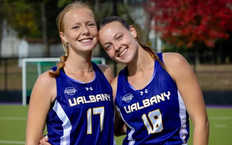 UAlbany senior field hockey players Alsion Smisdom and Floor de Ruiter standing on alumni field on the UAlbany campus. (Photo by Brent Warzocha/UAlbany Athletics)